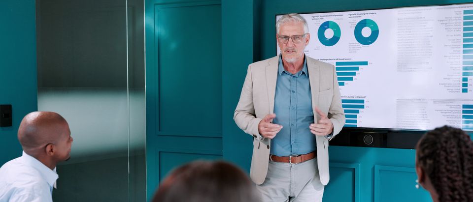 Financiële presentatie met grafieken op een scherm tijdens een overleg